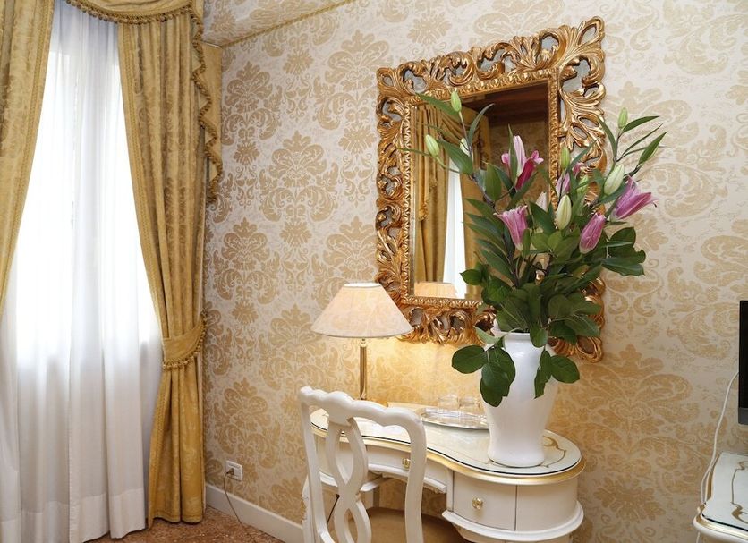 Cà Furlan Venice guest room with ornate mirror, desk, lamp, and gold drapes