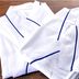 Folded white hotel robes with blue piping at Value the Hotel Ishinomaki in Ishinomaki