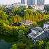 Paragon Hotel Xiangtan aerial view of villas by a lake and lush greenery with city towers behind