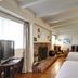 The Tides Laguna Beach room with two beds, brick fireplace, wood floors, and partial ocean-view artwork