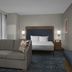Homewood Suites by Hilton Portsmouth Downtown room with sofa, king bed, and blue bench seating