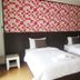 Baan Klang Hua Hin guest room with two twin beds and red patterned wall in Hua Hin