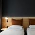 Moxy Milton Keynes twin bed guest room with wood headboard and reading lights
