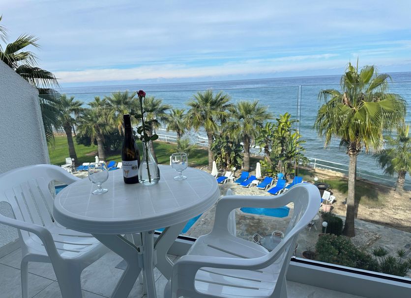 Souli Beach Hotel in Polis Chrysochous, balcony with sea view, table, chairs and palm trees