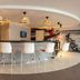 ibis Styles Lima Benavides Miraflores bar with white stools and modern pendant lights in Lima
