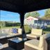 Best Motel Bowling Green outdoor seating area under a shaded cabana with white cushioned wicker furniture