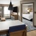 Candlewood Suites Williamsport suite with kitchenette, seating area, and bedroom doorway
