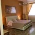 I Faraglioni, Terrasini hotel room with double bed, window with curtains, TV, and chandelier