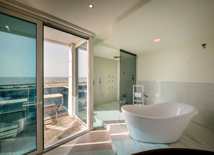 Hotel Panoramic Caorle bathroom with freestanding tub and glass doors opening to a sea-view terrace