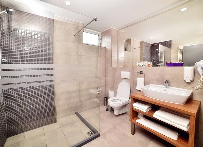 Hotel President Timisoara bathroom with glass shower, toilet and sink vanity