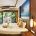 Ratana Hill Patong in Patong bedroom with king bed, balcony, palm tree view, desk, and wall-mounted TV