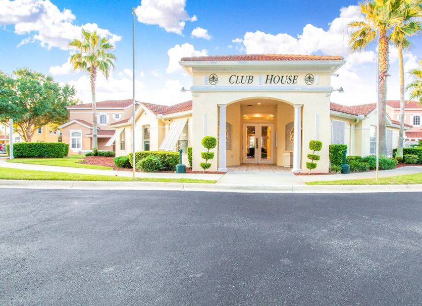 Berkley Lake Townhomes club house entrance in Kissimmee with palm trees and a bright front drive