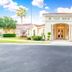 Berkley Lake Townhomes club house entrance in Kissimmee with palm trees and a bright front drive