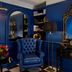 Holmes Hotel London in London featuring a blue lounge with a tufted armchair, ornate mirror, and fireplace