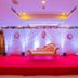 Hotel Grand Palace Chennai event stage with red carpet, floral drapes and ornate loveseat