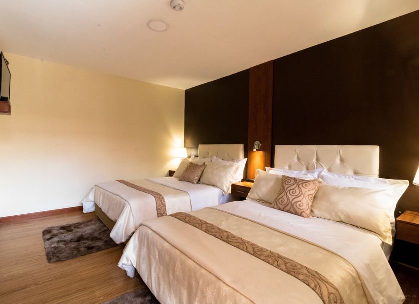 Hotel Boutique Castilla De Leon in Cuenca: twin beds in a simple guest room with warm lighting