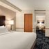 Fairfield Inn & Suites by Marriott Tupelo guest room with bed, TV, desk and seating area
