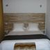 Hôtel En Ville room in Aix-en-Provence with double bed, wood headboard and colorful wall art