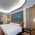 Shengshi Civil Aviation Hotel in Zhengzhou bedroom with king bed, geometric ceiling, and wall mural