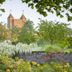 London Beach Country Hotel & Golf Club in Tenterden, garden view with flowering trees and castle-like tower