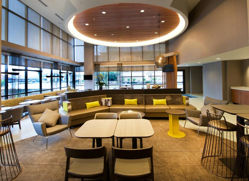 SpringHill Suites by Marriott Seattle Issaquah lobby lounge with curved seating, tables and large windows