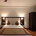 Hotel Waves, Delhi Airport in New Delhi: double bed with tufted headboard, bedside lamps and wardrobe