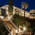 Le Mirage in Bormes-les-Mimosas at night, with lit exterior stairs, palm trees, and hillside gardens