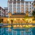 Lijiang International Hotel in Lijiang with a pool reflecting the hotel facade at dusk