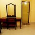 Karthika Residency in Munnar room with desk, mirror, chairs and small TV on stand