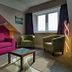 Bryn Melyn Apartments, Barmouth: bright lounge with pink sofa, armchairs, coffee table and window