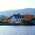 Landhaus Zu den Rothen Forellen in Ilsenburg by a lake with mountain backdrop and autumn trees