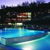 Village Cabo Girao in Câmara de Lobos with illuminated outdoor pool and resort buildings at dusk