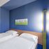 B&b Hotel Erlangen-tennenlohe room with two twin beds and a blue accent wall in Erlangen