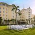 British Colonial Nassau in Nassau, with lawn seating, palm trees, and sunlit hotel façade