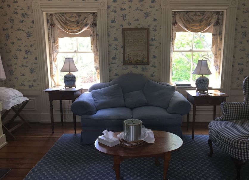 Spread Eagle Tavern and Inn in Hanoverton guest room with blue loveseat, twin lamps, and floral wallpaper