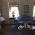 Spread Eagle Tavern and Inn in Hanoverton guest room with blue loveseat, twin lamps, and floral wallpaper