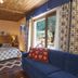 Miramonti in Valtournenche bedroom with wood ceiling, blue sofa, and balcony view