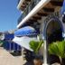 Hotel Casa Vieja in Puerto Escondido with blue awnings, arched entrance, and palm planters
