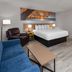 Days Inn by Wyndham Mason City guest room with king bed, armchair, sofa and small table