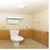 Hotel NavaRATNA in Coimbatore bathroom with toilet, tiled walls, and ceiling light