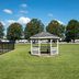 Red Roof Inn Kenly - I-95 gazebo on a grassy lawn with trees and a blue sky in Kenly