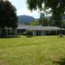 Stevens Pass Motel in Gold Bar with grassy lawn, mountain backdrop, and single-story motel exterior