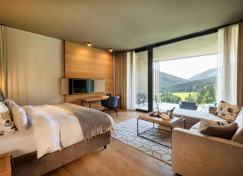 Almwellness Hotel Pierer in Fladnitz guest room with balcony mountain views and seating area