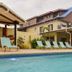 Elite Hotel in Port Au Prince with outdoor pool, lounge chairs, and covered patio