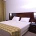 Golden Tulip Kumasi City room with king bed, window seating and table in Kumasi
