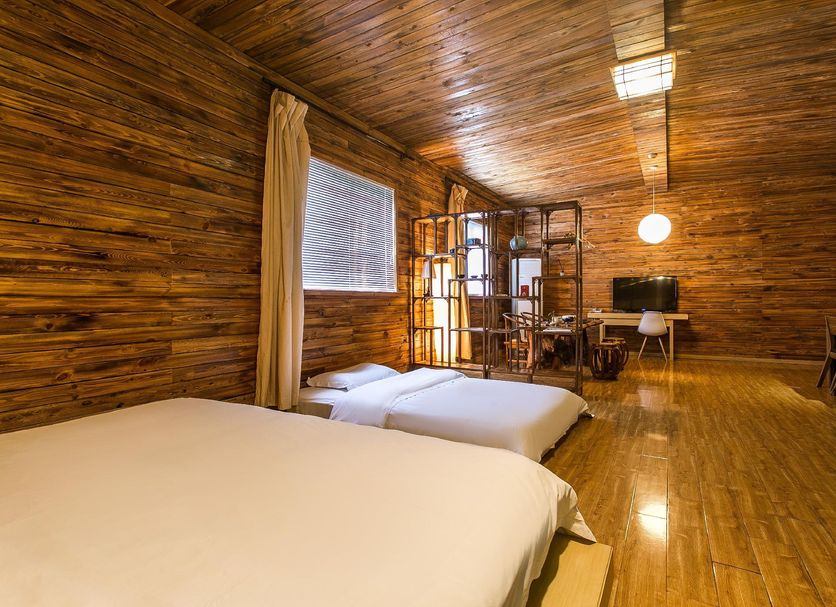 Home++ Xi'an in Xi'an: rustic wooden guest room with two beds, desk, and warm ambient lighting