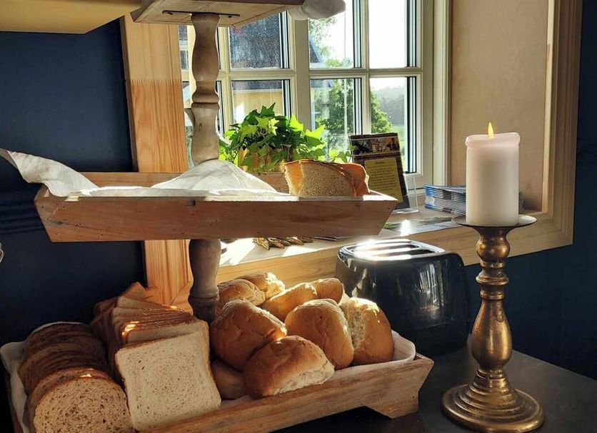 Älgbergets Bed & Breakfast in Stenungsund breakfast buffet with bread rolls, sliced bread, and a lit candle