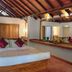 The Deer Park Hotel in Giritale bedroom with wood-beam ceiling, king bed, and large wall mirror