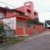 Pousada Ilha Morena in Florianopolis, coral hotel exterior with gated entrance and street view