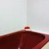 Global Hotel Labuan bathroom with a deep red bathtub and white tiled walls